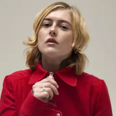 Ellen Krauss i röd manchesterjacka, med fingret vid dragkedjan.