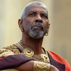 Denzel Washington med grått skägg och guldörhängen, klädd i en historisk dräkt. En ikonisk skådespelare känd från många denzel washington movies.