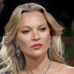 Kate Moss-stil med blont hår, diamantörhängen och en elegant halsband.