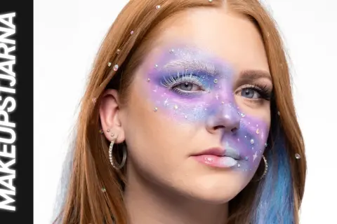 En ung kvinna med fantasifull makeup som påminner om siren eyes, med lila och blåa färger, glitter och strass.
