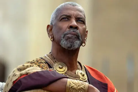 Denzel Washington med grått skägg och guldörhängen, klädd i en historisk dräkt. En ikonisk skådespelare känd från många denzel washington movies.
