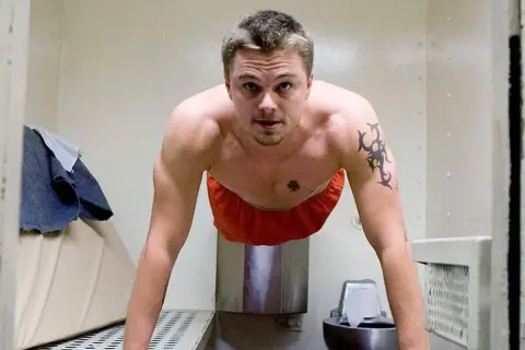 Leonardo DiCaprio gör armhävningar i ett fängelse. En scen från filmer med Leonardo DiCaprio.