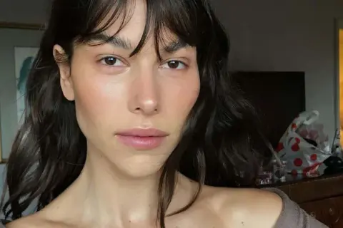 Helena Vestergaard med mörkt hår och lugg, med en naturlig makeup som framhäver hennes drag.