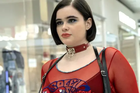 Kat från Euphoria med blå ögonskugga och röd choker.
