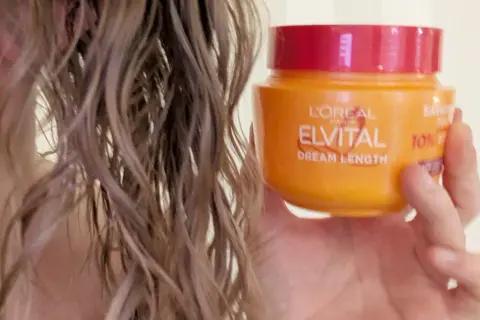 En hand håller en burk L'Oréal Elvital Dream Length. En hemmakur för torrt hår som behöver räddas.