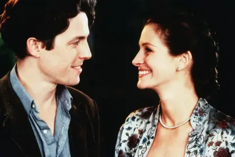 Hugh Grant och Julia Roberts ler mot varandra i en klassisk scen från en av deras mest älskade romantiska komedier.