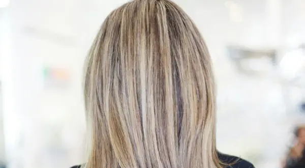 En frisyr med brunt hår med kalla slingor som ger en naturlig och modern look.