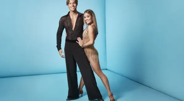 Lets dance deltagare redo för dansgolvet. Han i svart skjorta med stenar, hon i glittrig gul klänning.