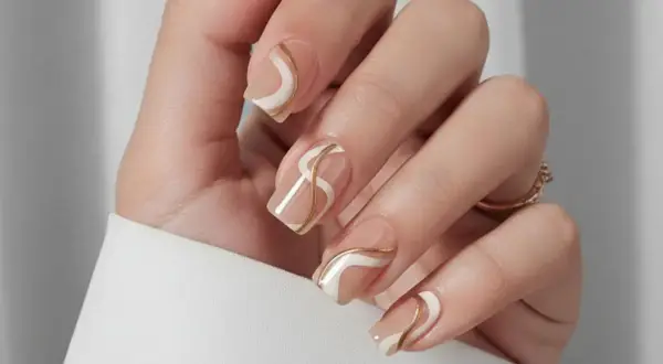 Naglar med en elegant design i beige, vitt och guld. Perfekt naglar inspiration sommar för en sofistikerad look.