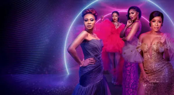Fyra kvinnor i glittrande klänningar poserar framför en neonljusring. En scen som hämtad ur de mest glamorösa fashion movies.