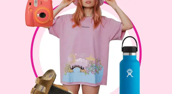 En vsco girl med rosa t-shirt, bucket hat, Instax-kamera, Birkenstocks och en blå Hydro Flask.