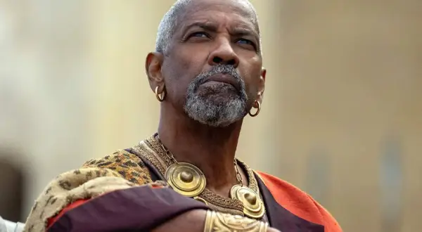 Denzel Washington med grått skägg och guldörhängen, klädd i en historisk dräkt. En ikonisk skådespelare känd från många denzel washington movies.