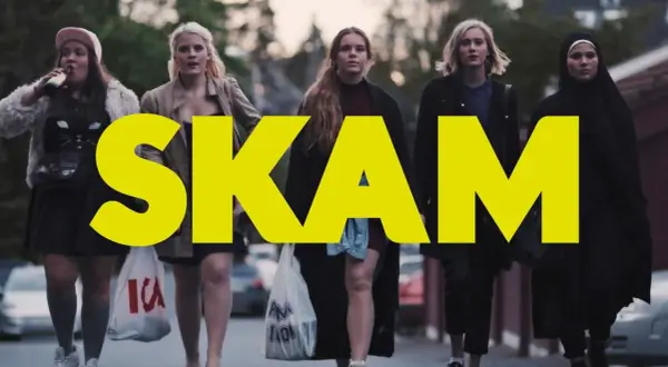 Fem tjejer går på gatan, med den stora gula texten "SKAM" över bilden. En av dem dricker ur en flaska.