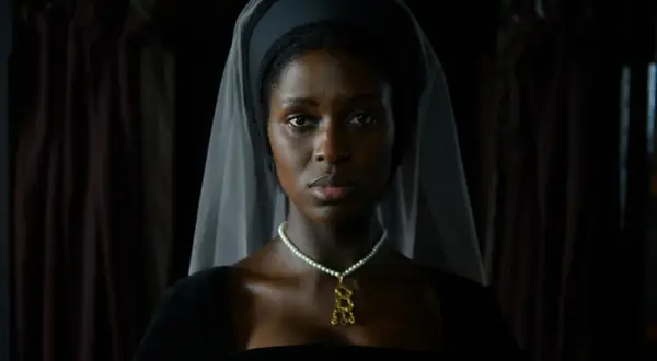 En kvinna i historisk dräkt, med slöja och pärlhalsband, i en scen från anne boleyn series.