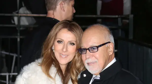 Celine Dion och en man med glasögon, en del av en säkerhetsvakt syns i bakgrunden.