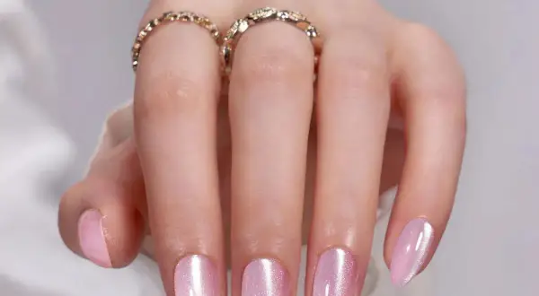 Vackra ljusrosa naglar med skimrande finish. Perfekt nagel inspo för en mjuk och elegant look. Två ringar pryder fingrarna.