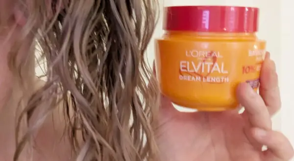 En hand håller en burk L'Oréal Elvital Dream Length. En hemmakur för torrt hår som behöver räddas.