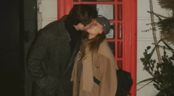 Phillipe Cohen och Rebecca kysser varandra passionerat framför en röd dörr.
