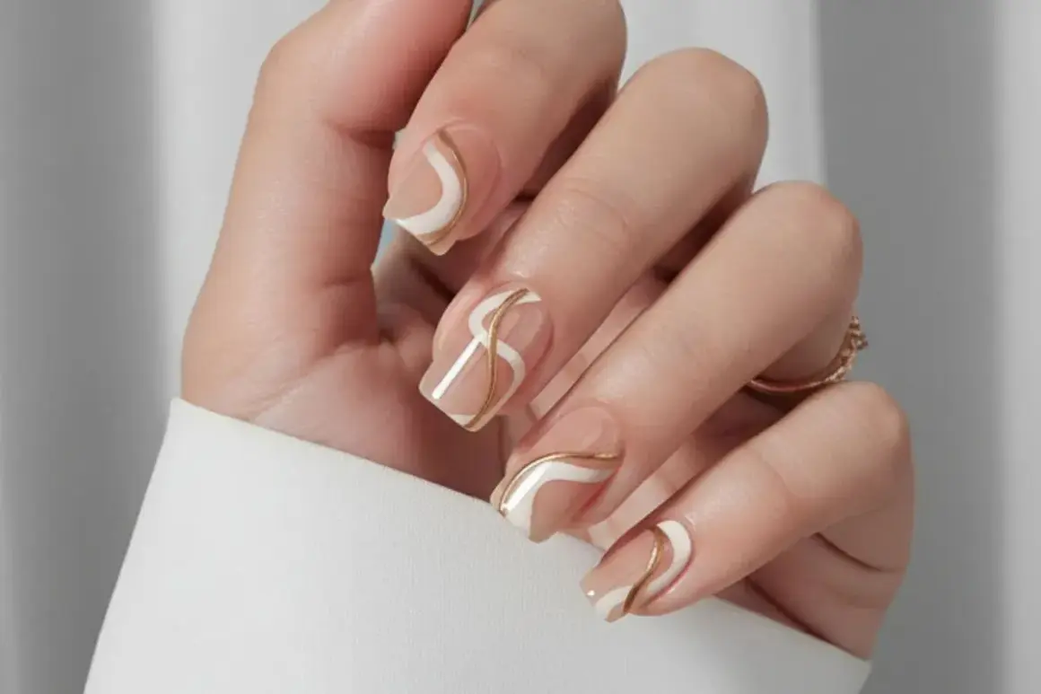 Naglar med en elegant design i beige, vitt och guld. Perfekt naglar inspiration sommar för en sofistikerad look.