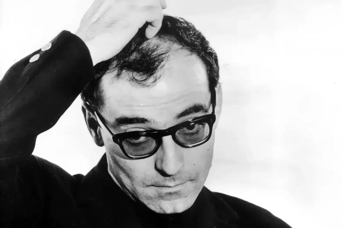 Jean-Luc Godard, en ikonisk filmskapare, med handen i håret. Hans filmer med Jean-Luc Godard är banbrytande.