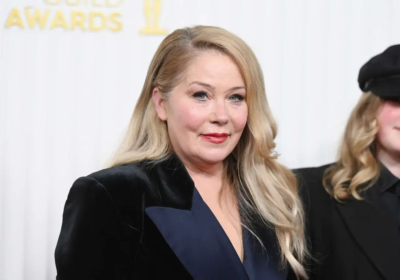 Christina Applegate ms. med blont hår och rött läppstift bär en svart sammetsjacka.