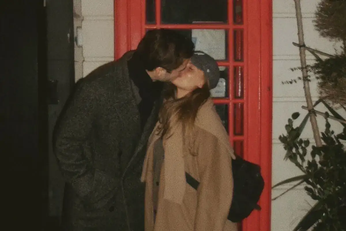 Phillipe Cohen och Rebecca kysser varandra passionerat framför en röd dörr.
