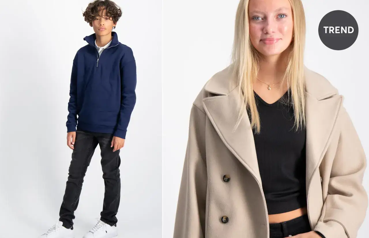 Ung kille i mörkblå sweatshirt och svarta jeans, samt en tjej i beige kappa. Street style Stockholm.
