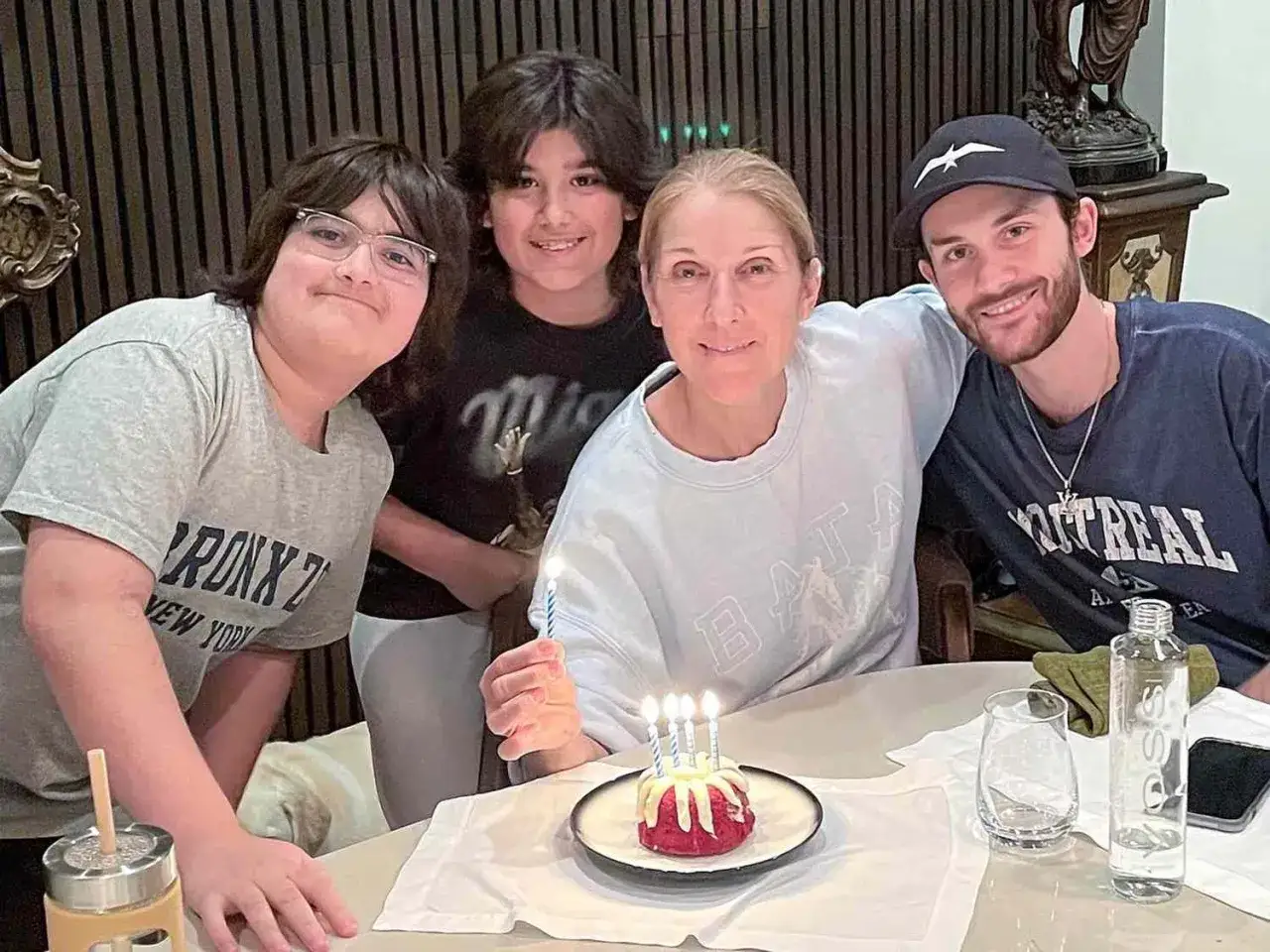 Celine Dion firar med sina barn runt ett födelsedagstårt.