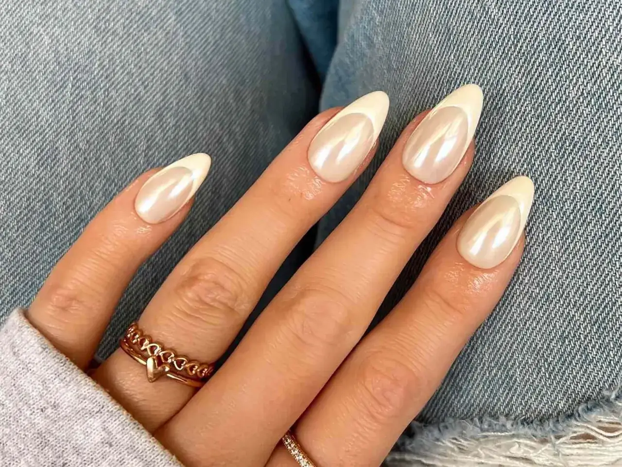 Vackra mandelformade naglar med pärlemorskimrande finish och vit fransk kant. Perfekt almond nails inspo för en elegant look.
