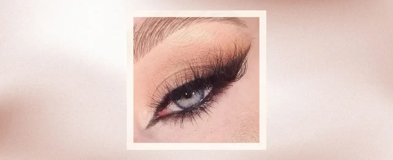 En närbild på ett öga med dramatisk eyeliner och lösögonfransar, som ger en 