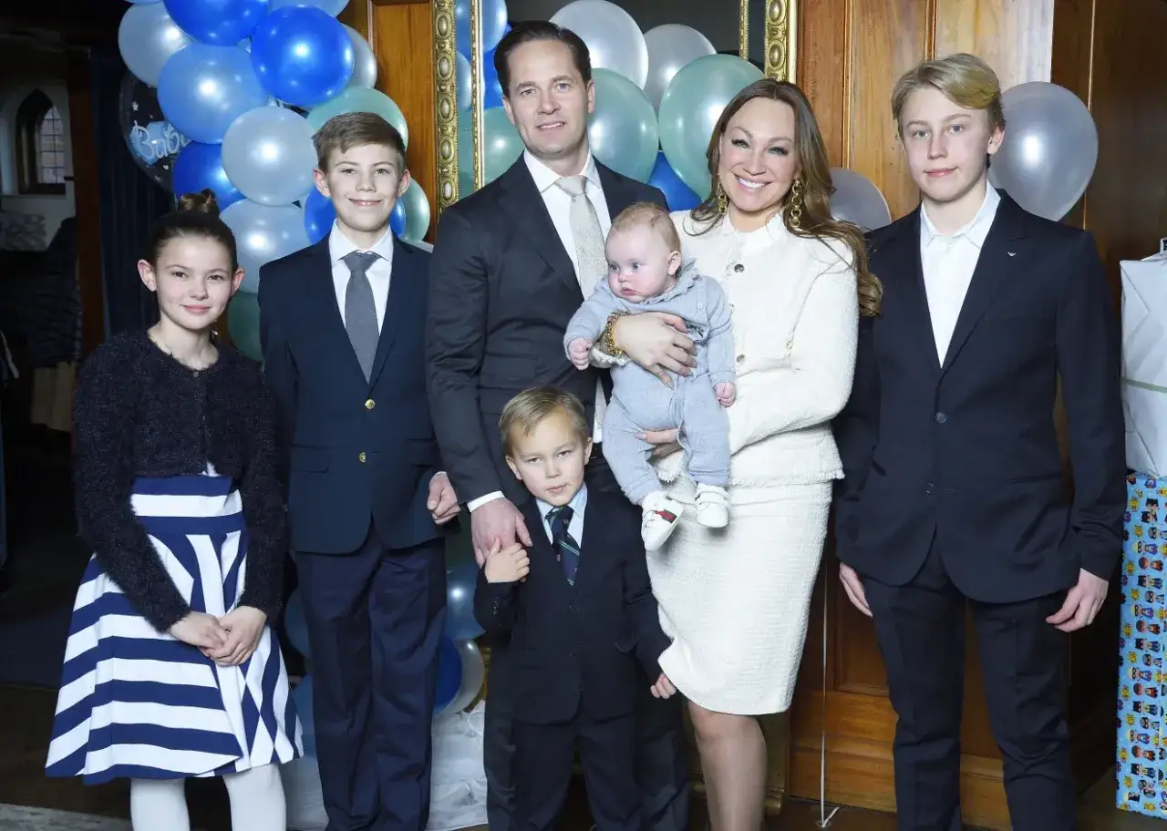 Familjen Nicola Perrelli med sina barn, inklusive en bebis, firar med ballonger.