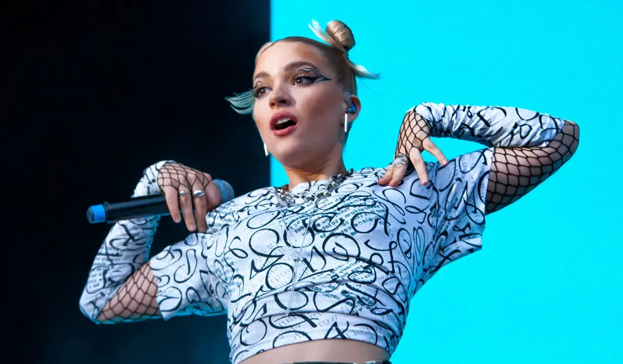 Tove Styrke sjunger med energi på scenen, klädd i en mönstrad topp och fisknätstrumpor.