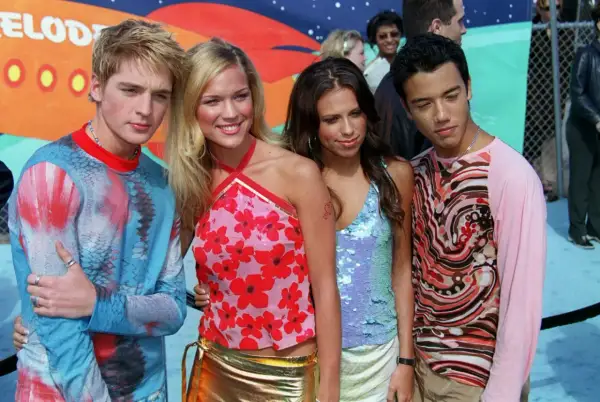 A-Teens comeback! Fyra medlemmar poserar glatt i färgglada kläder.