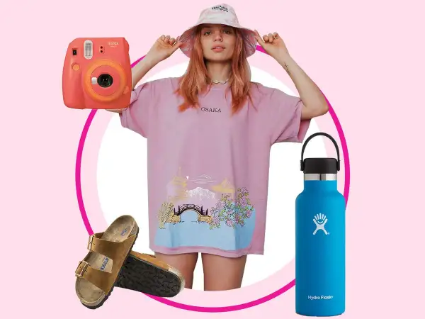 En vsco girl med rosa t-shirt, bucket hat, Instax-kamera, Birkenstocks och en blå Hydro Flask.