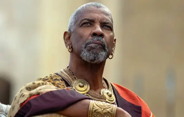 Denzel Washington med grått skägg och guldörhängen, klädd i en historisk dräkt. En ikonisk skådespelare känd från många denzel washington movies.