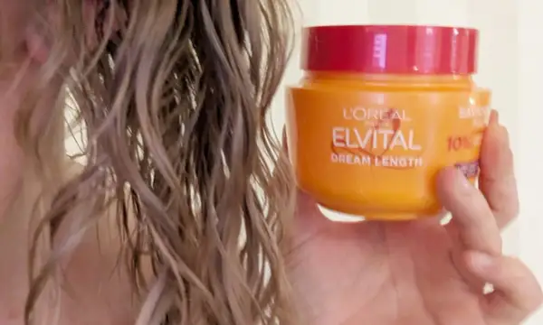 En hand håller en burk L'Oréal Elvital Dream Length. En hemmakur för torrt hår som behöver räddas.